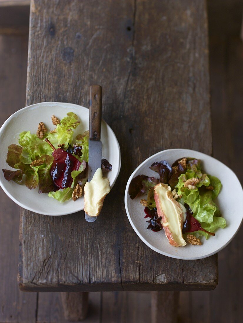 Zwei Teller Eichblattsalat mit Rotweinbirne und Epoisses