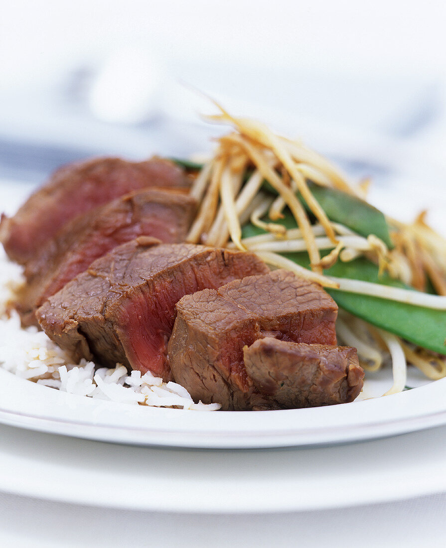 Pieces of beef fillet with sprouts, mangetout and rice