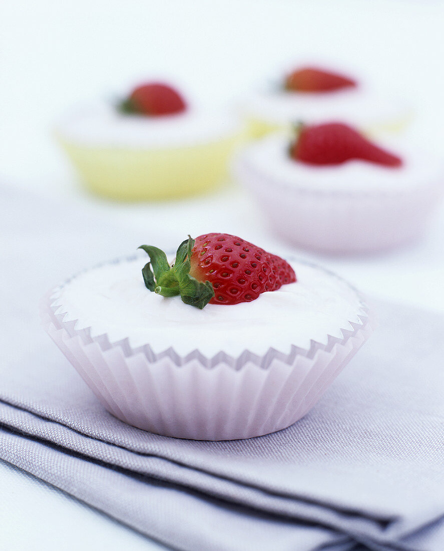 Yoghurt cream with strawberries in four paper cases