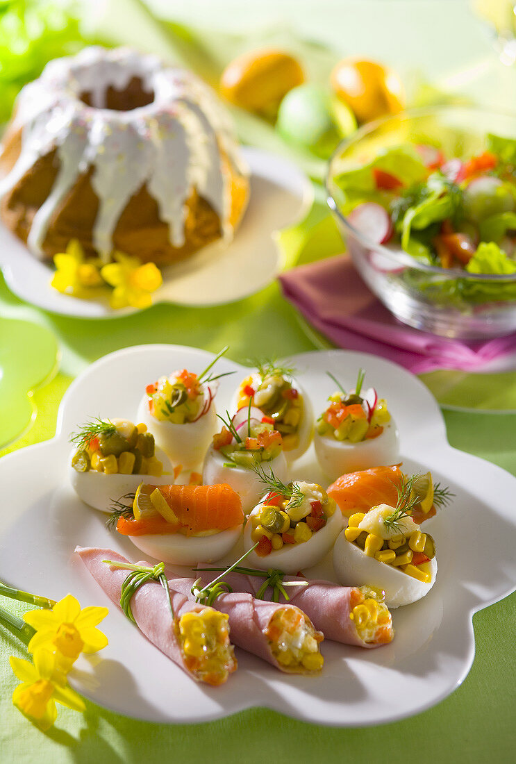 Gefüllte Eier und Schinkenröllchen auf einem Ostertisch