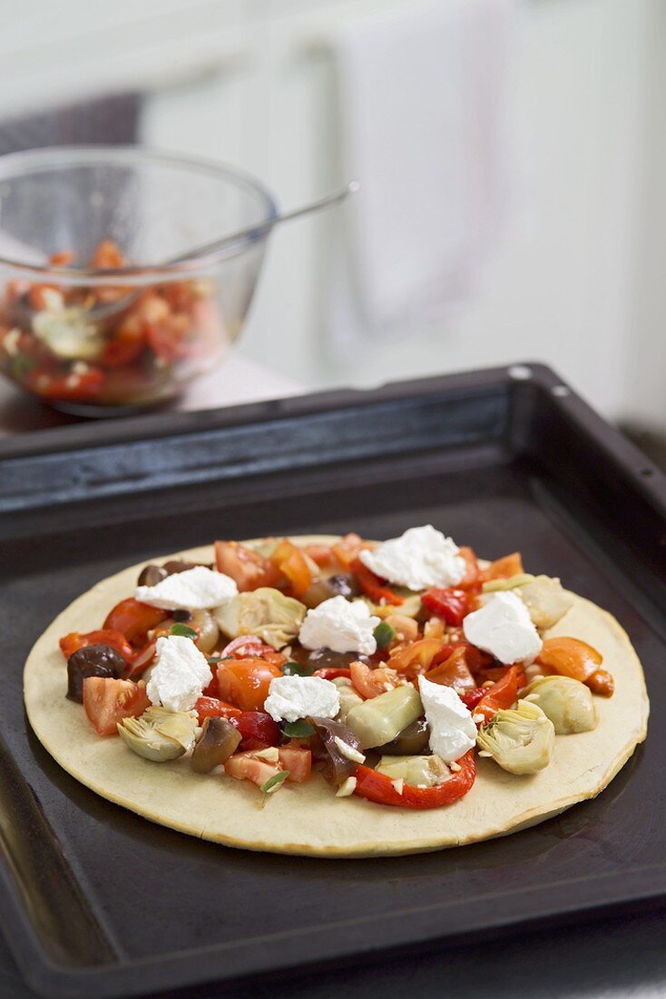 Eine ungebackene, vegetarische Pizza auf einem Backblech