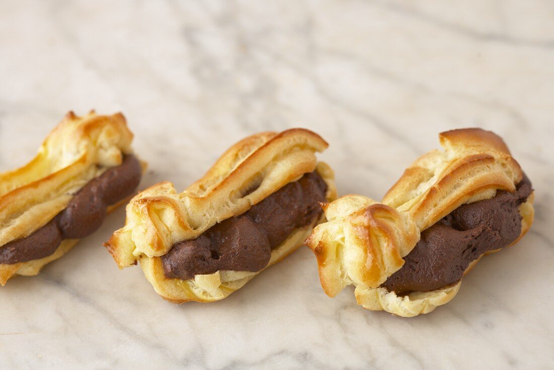 Drei Eclairs mit Schokoladen-Kaffee-Creme gefüllt