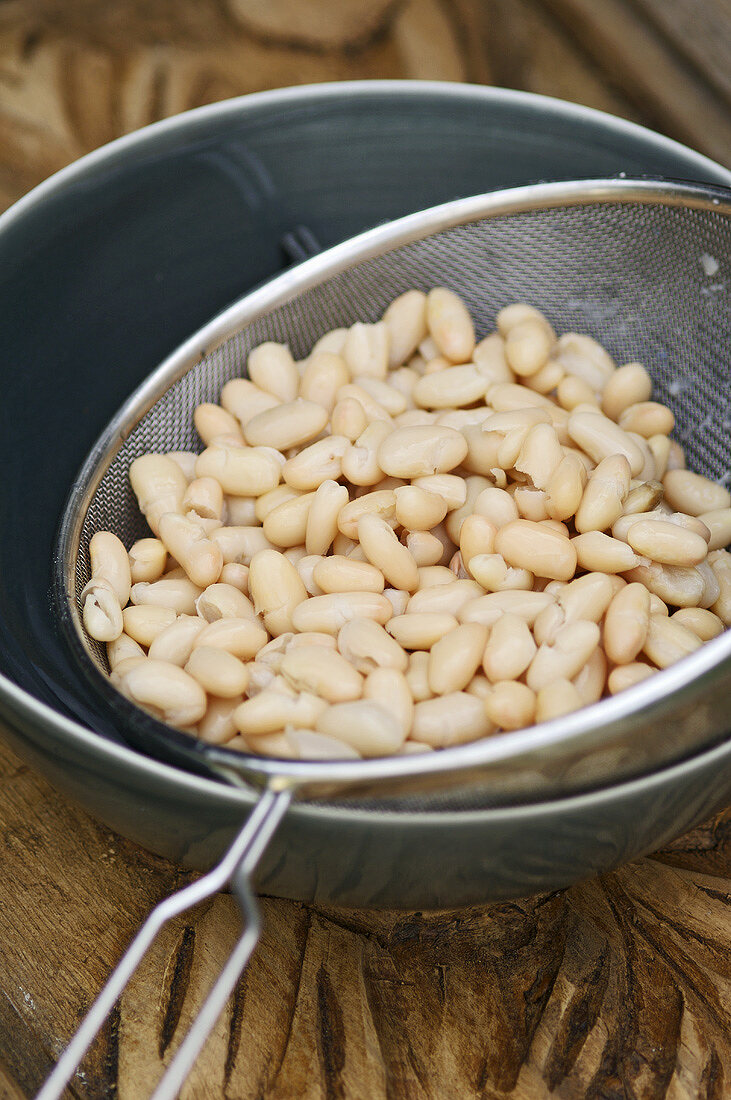 Tinned white beans in a sieve