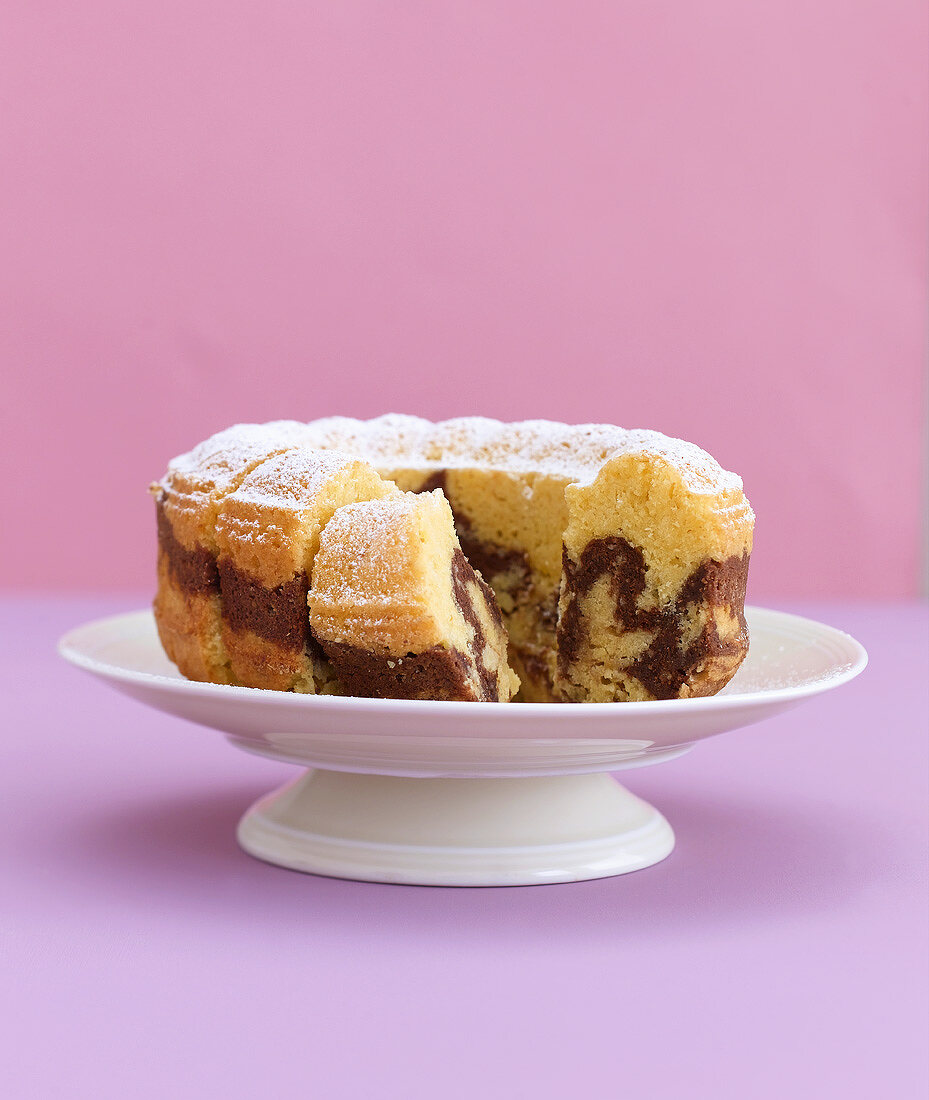 Marble cake, partly sliced, on a cake stand