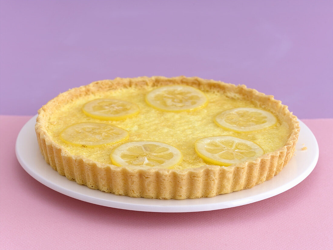 A lemon tart on a cake plate