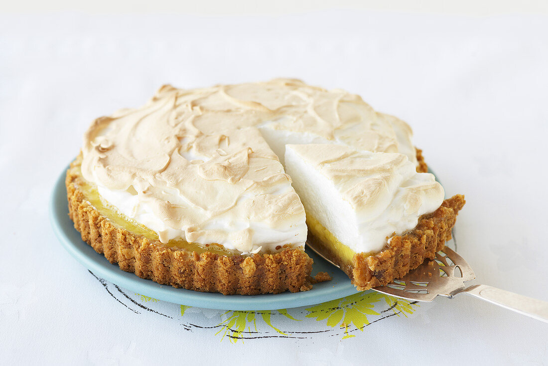 Key Lime Pie mit herausgeschnittenem Stück auf Tortenheber