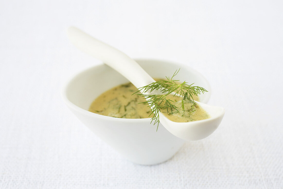 A dish of mustard and dill sauce with china spoon