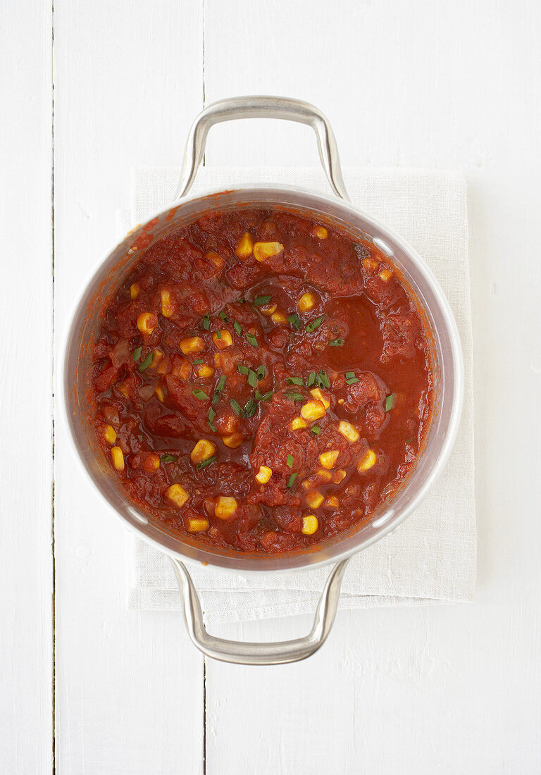 Tomato sauce with sweetcorn and chives in a pan