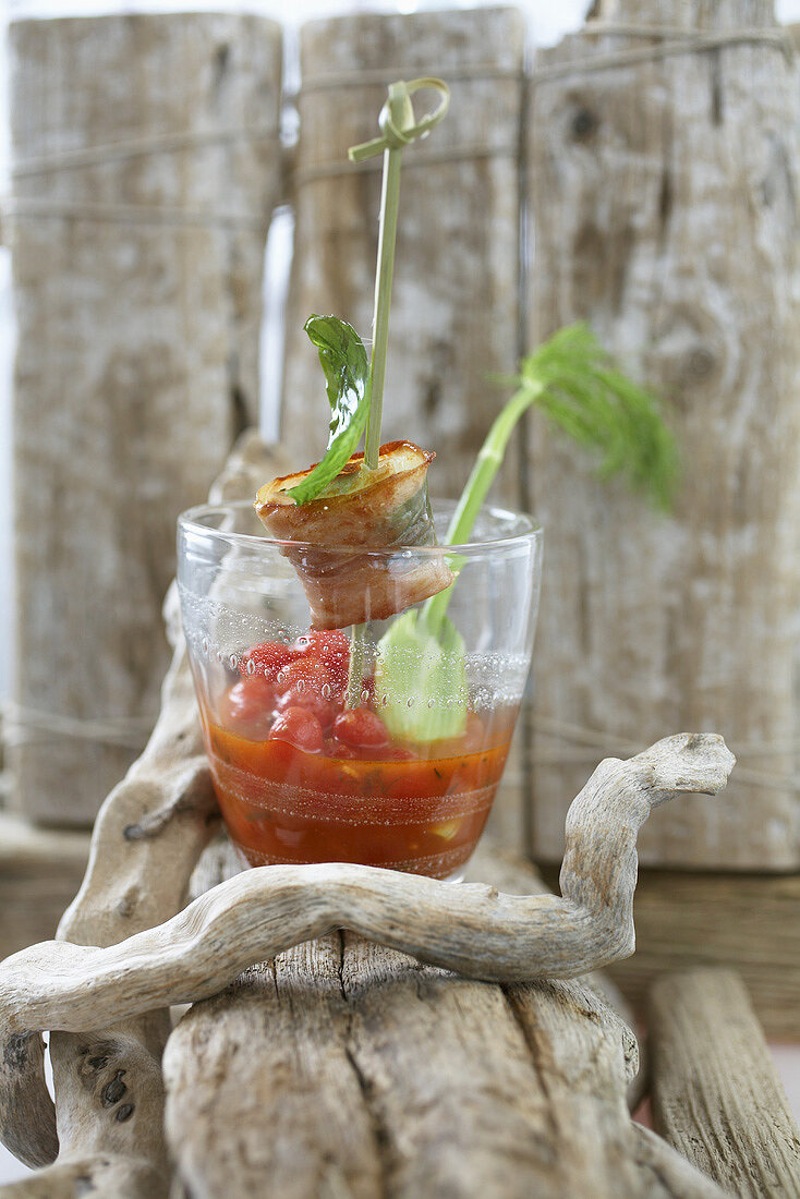 Cold cherry tomato soup in glass with halibut saltimbocca