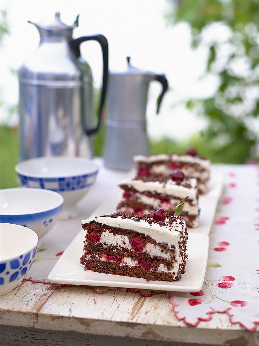 Three pieces of Black Forest gateau & coffee out of doors