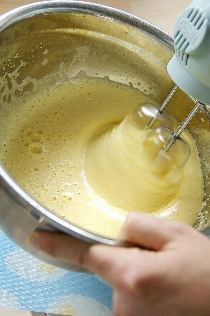 Beating lemon & egg yolk mixture with electric hand mixer