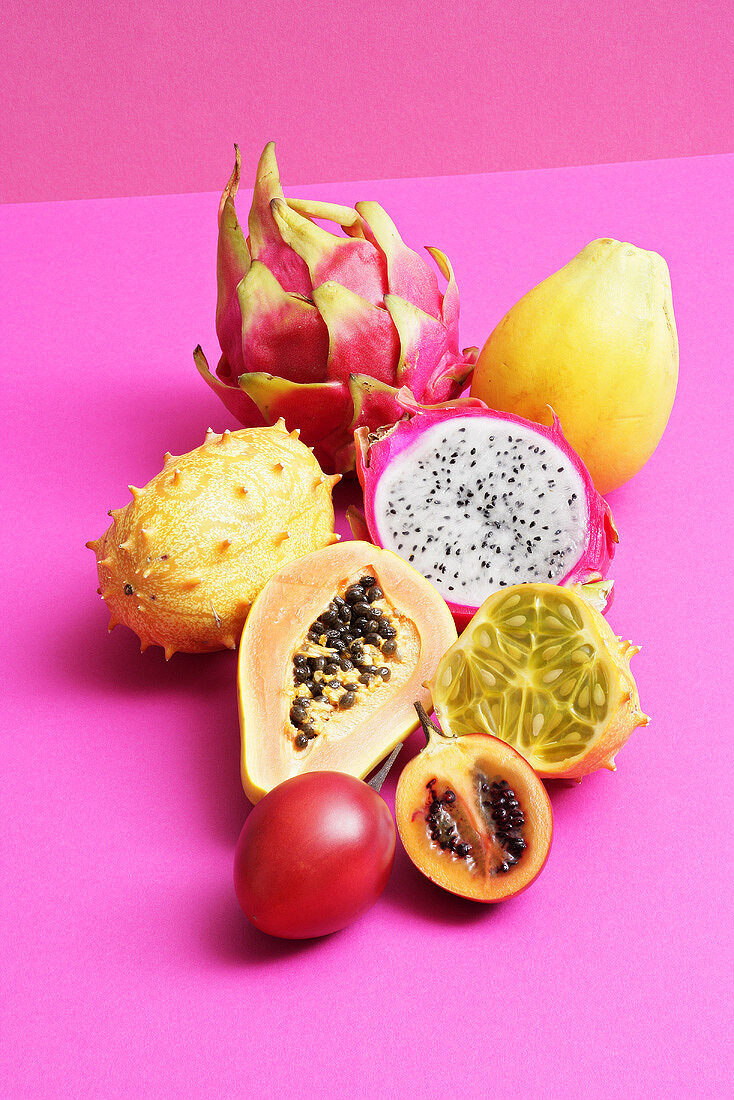 An assortment of exotic fruits, whole and halved