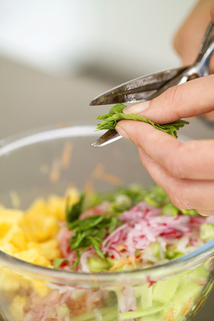 Snipping herbs into wrap filling with scissors