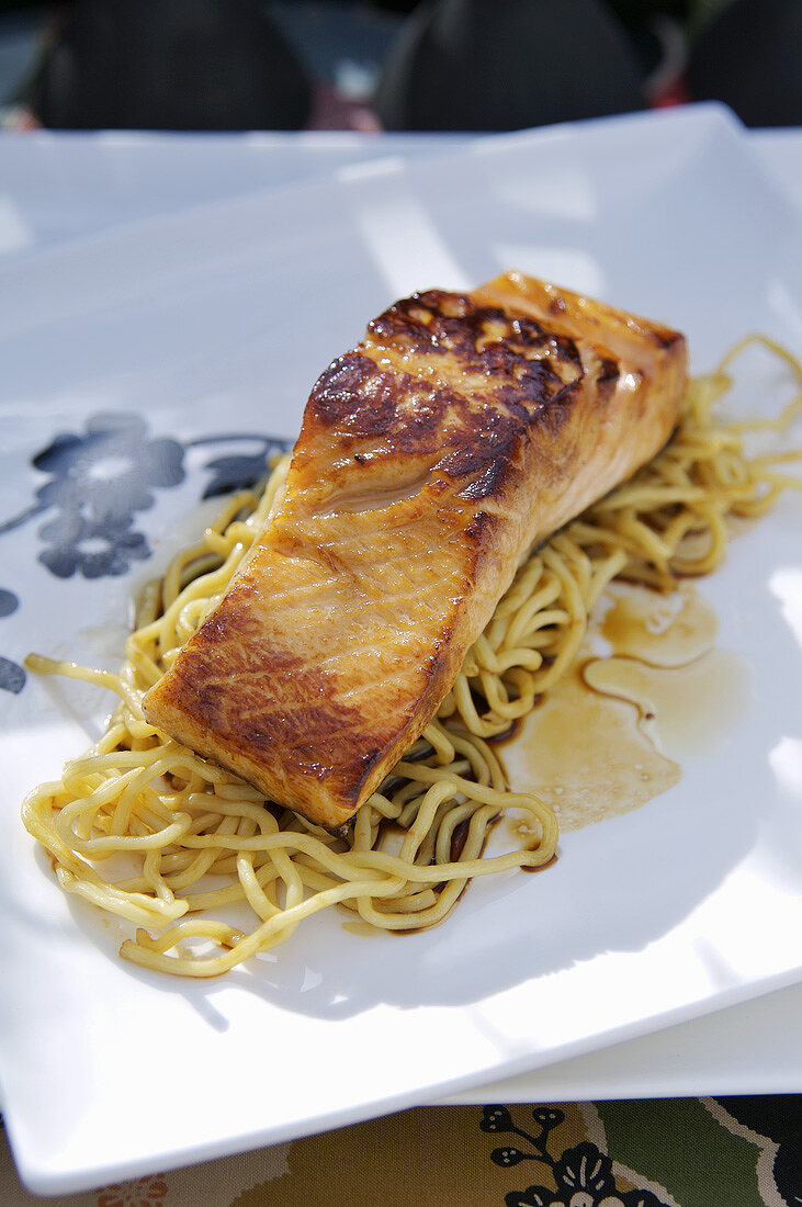 Fried salmon on noodles with soy sauce