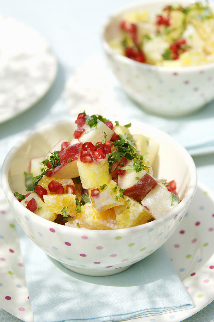 Two bowls of fruit salad with basil