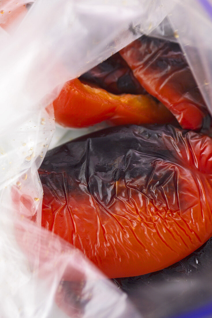 Grilled peppers in a plastic bag before being skinned