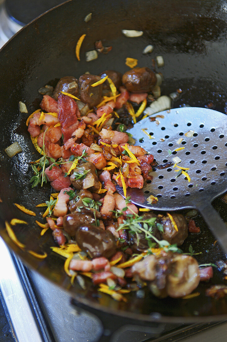 Sautéing bacon and orange zest in a frying pan