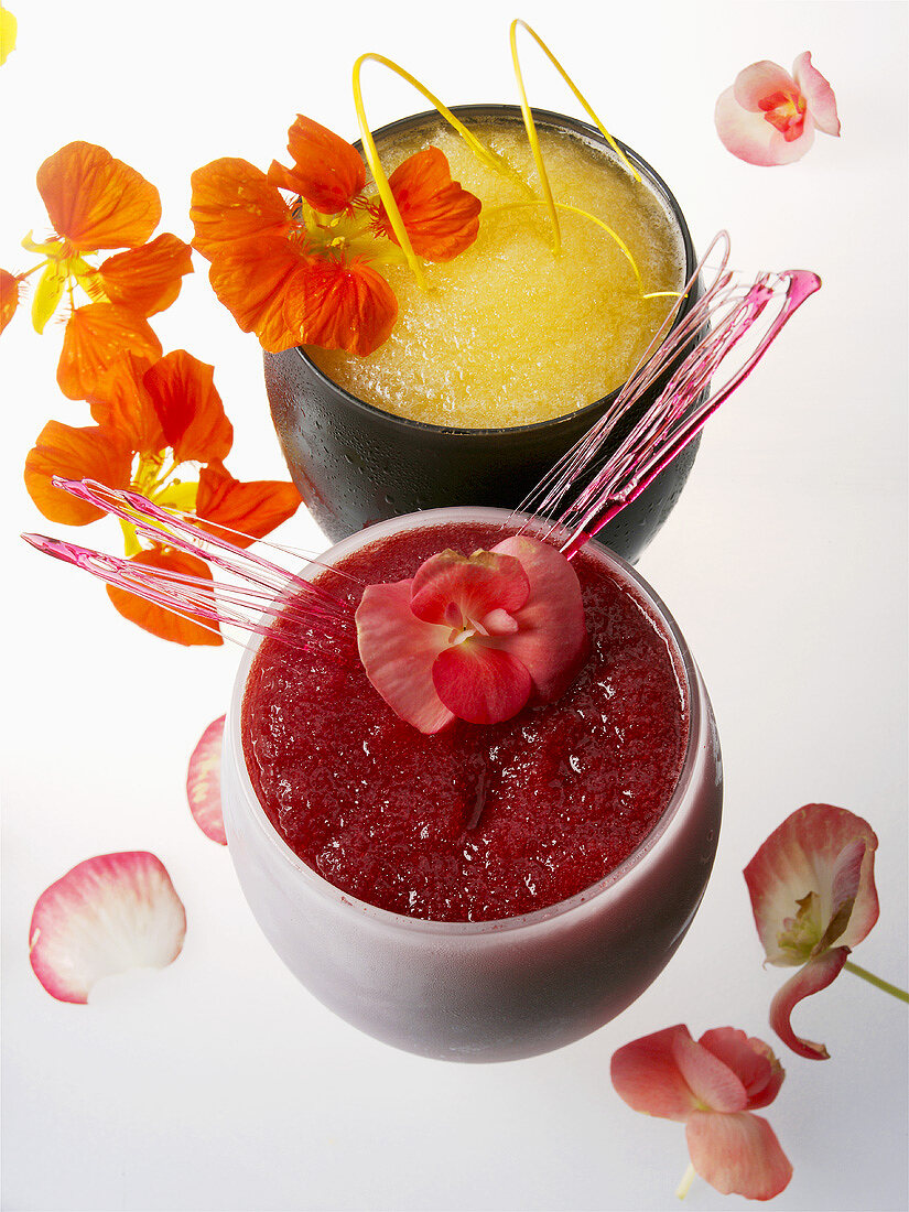 Roter und gelber Frucht-Coaktail mit Blüten