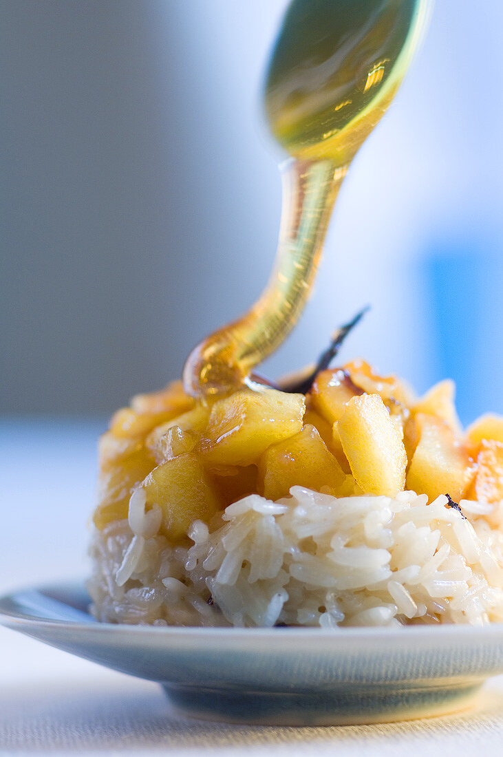 Pouring honey over rice and apple dessert