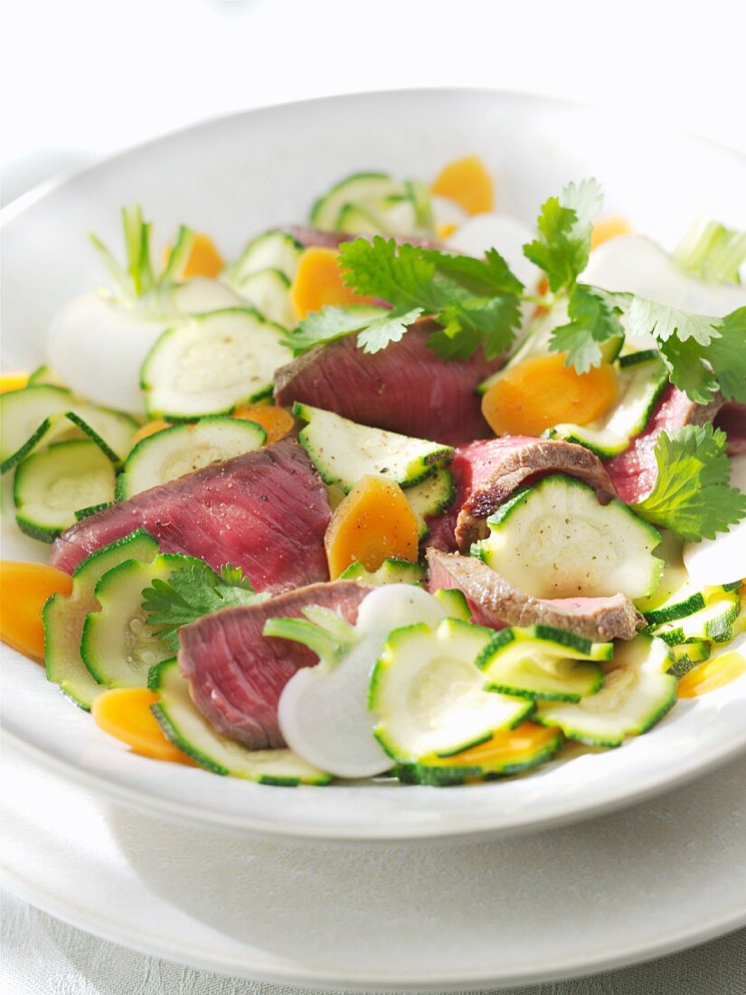 Vegetable salad with slices of fillet steak and coriander