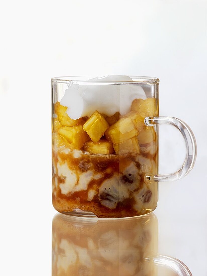 Pineapple in honey & sake with coconut foam in a glass mug