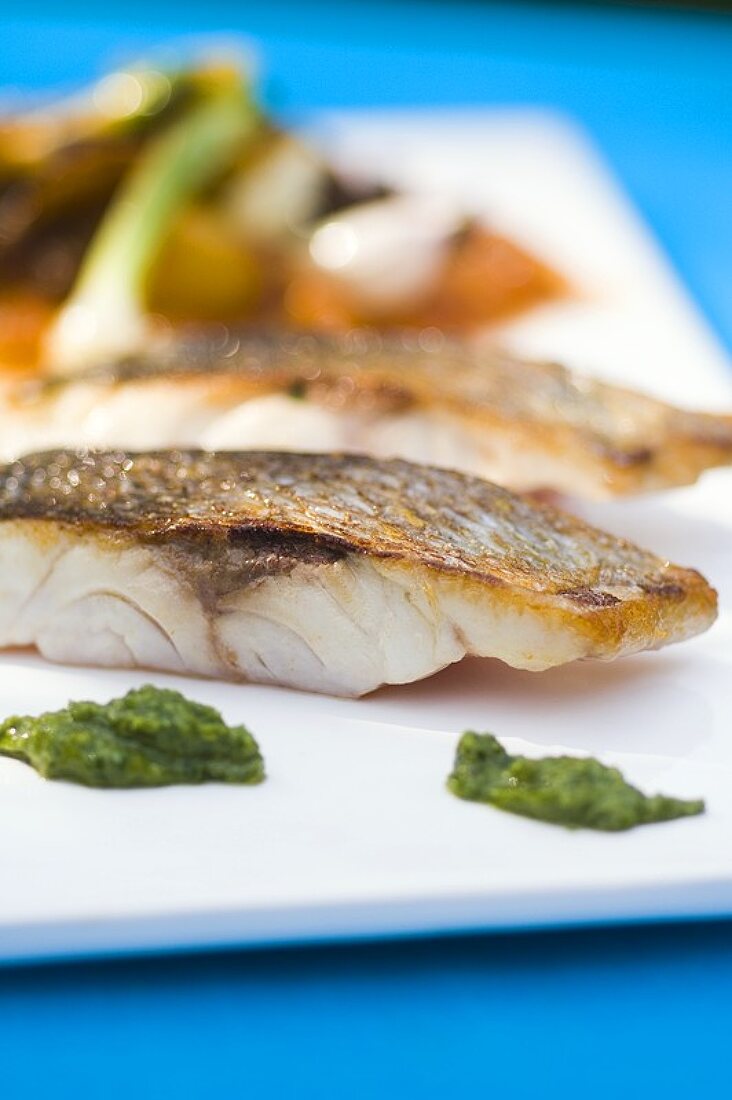 Fried sea bass with pesto and vegetables
