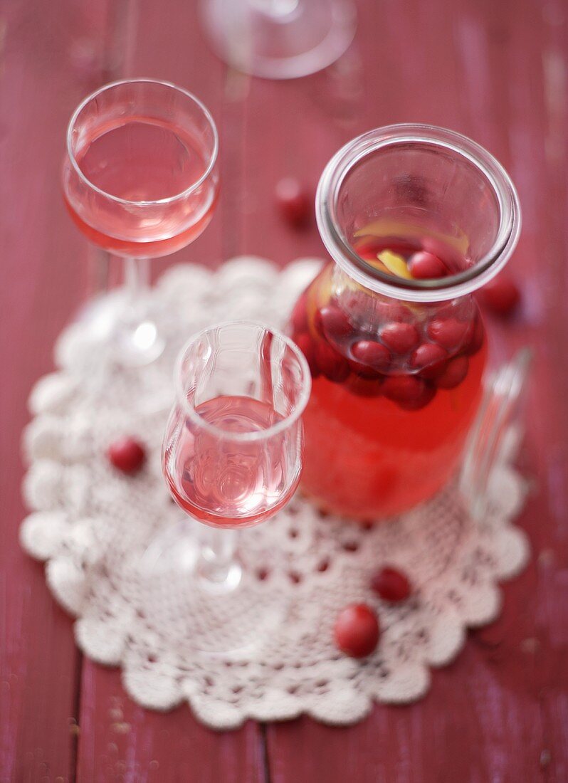 Cranberry-Likör in einer Karaffe und in Gläsern