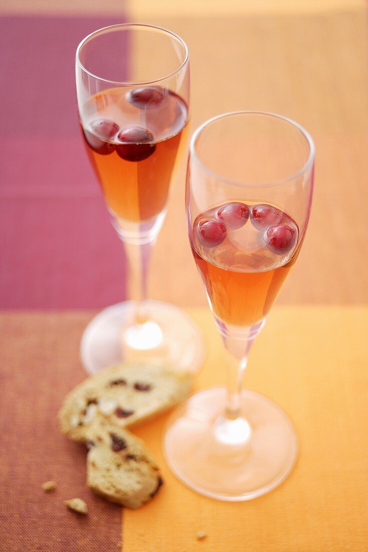Two glasses of cranberry vodka with cantuccini