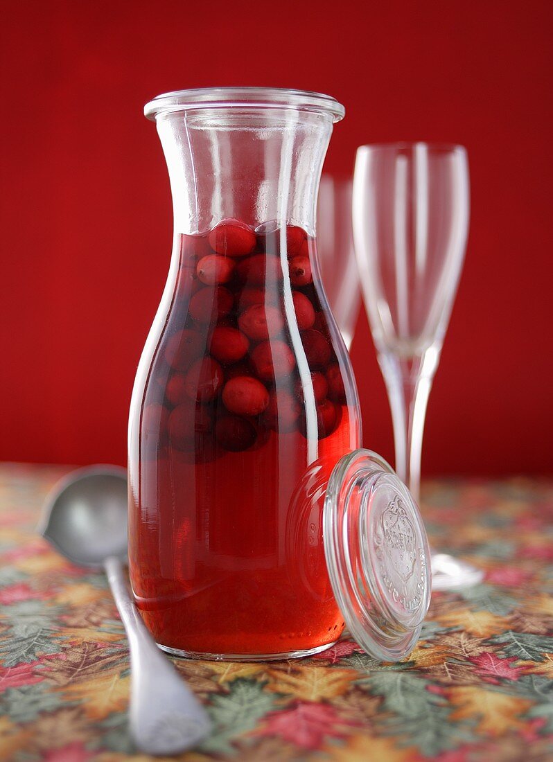 Home-made cranberry liqueur in a glass carafe
