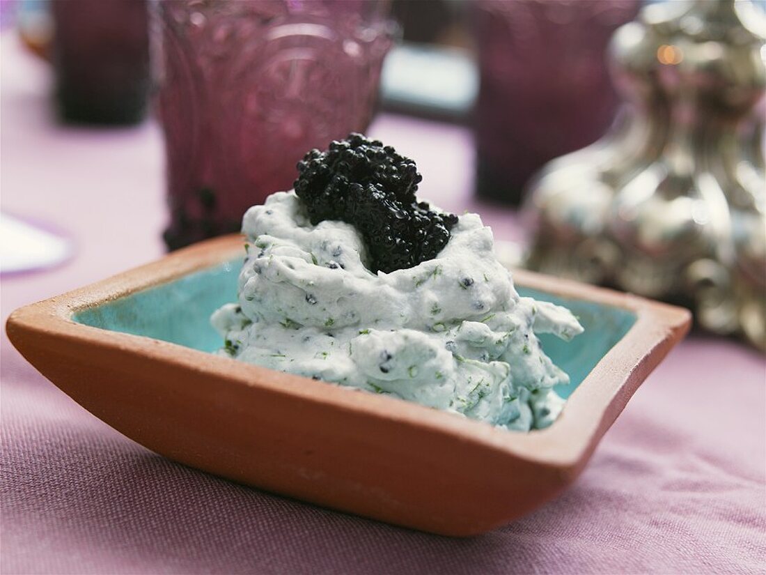 Caviar and sour cream dip in a terracotta dish
