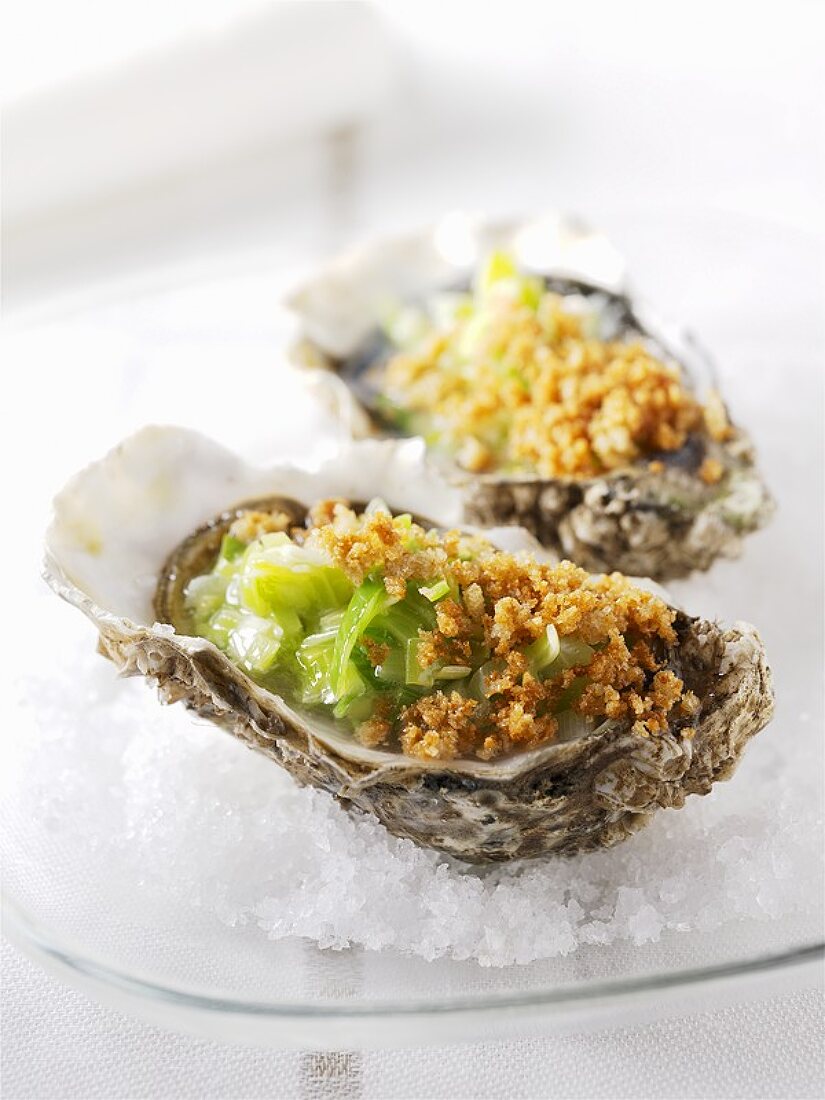 Two baked oysters with leeks on a bed of salt