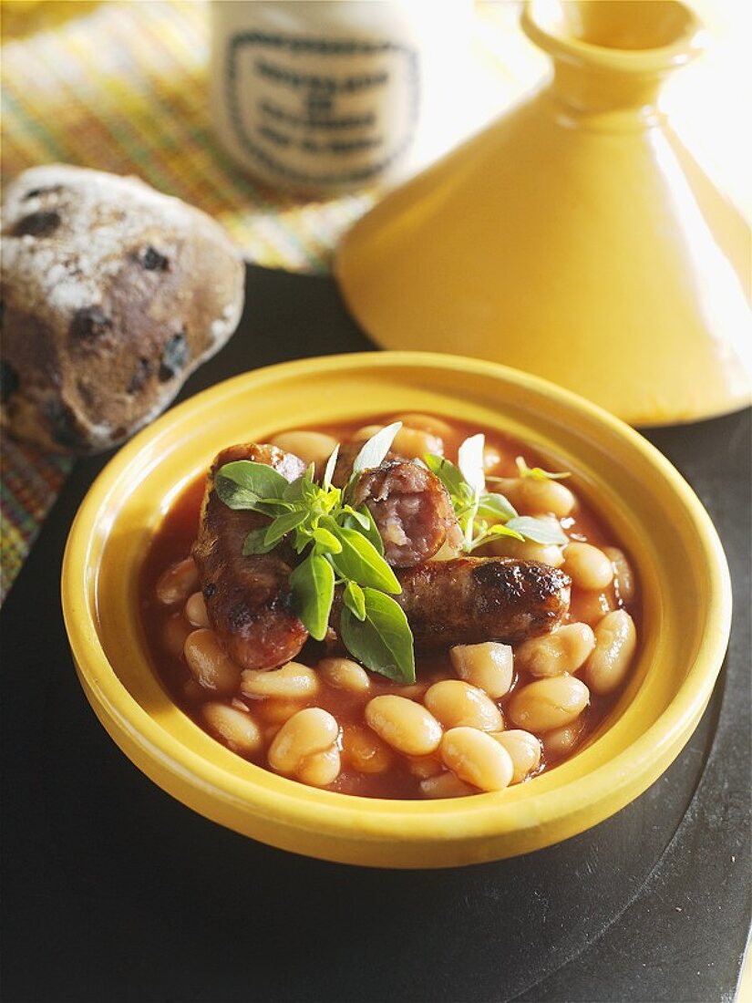 Tomaten-Bohneneintopf mit Würstchen in einer Tajine