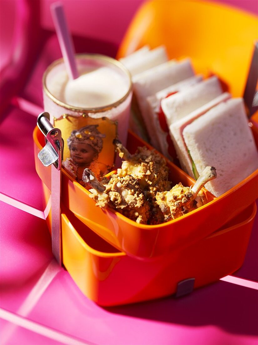 Sandwiches, fried chicken and milk in sandwich box