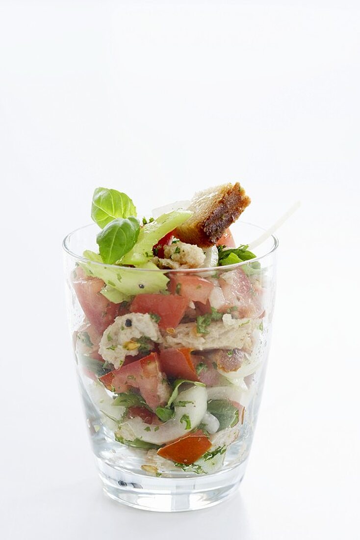 Bread, cucumber and tomato salad with basil in a glass
