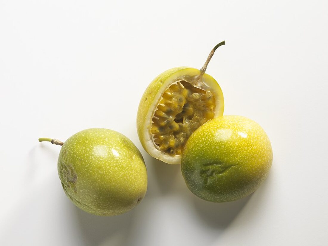 Whole and halved green passion fruit