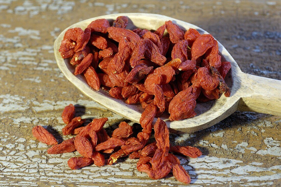 Dried goji berries on a wooden spoon