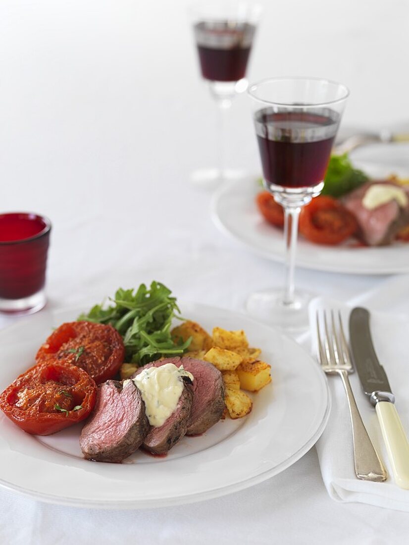 Slices of beef fillet with fried tomatoes and potatoes