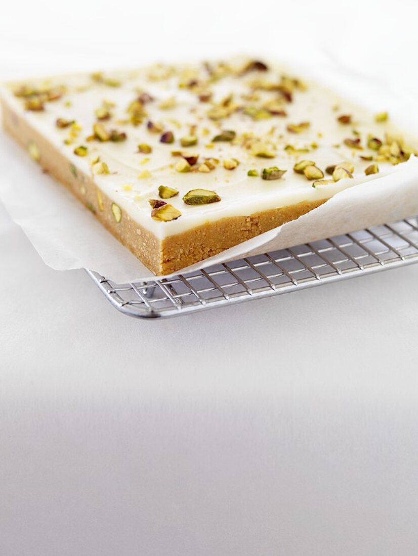 Lime and pistachio slice on a cake rack