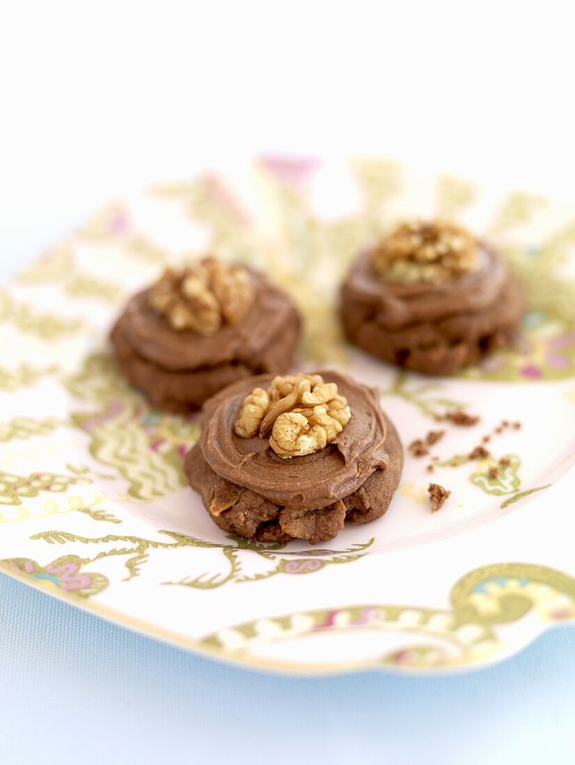 Three chocolate walnut biscuits on a plate