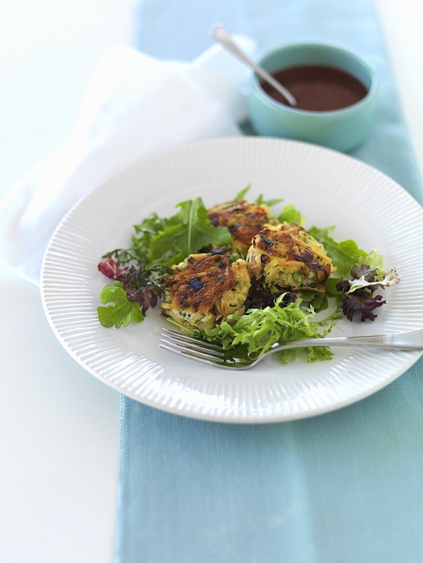 Smoked fish cakes on salad leaves with chilli sauce