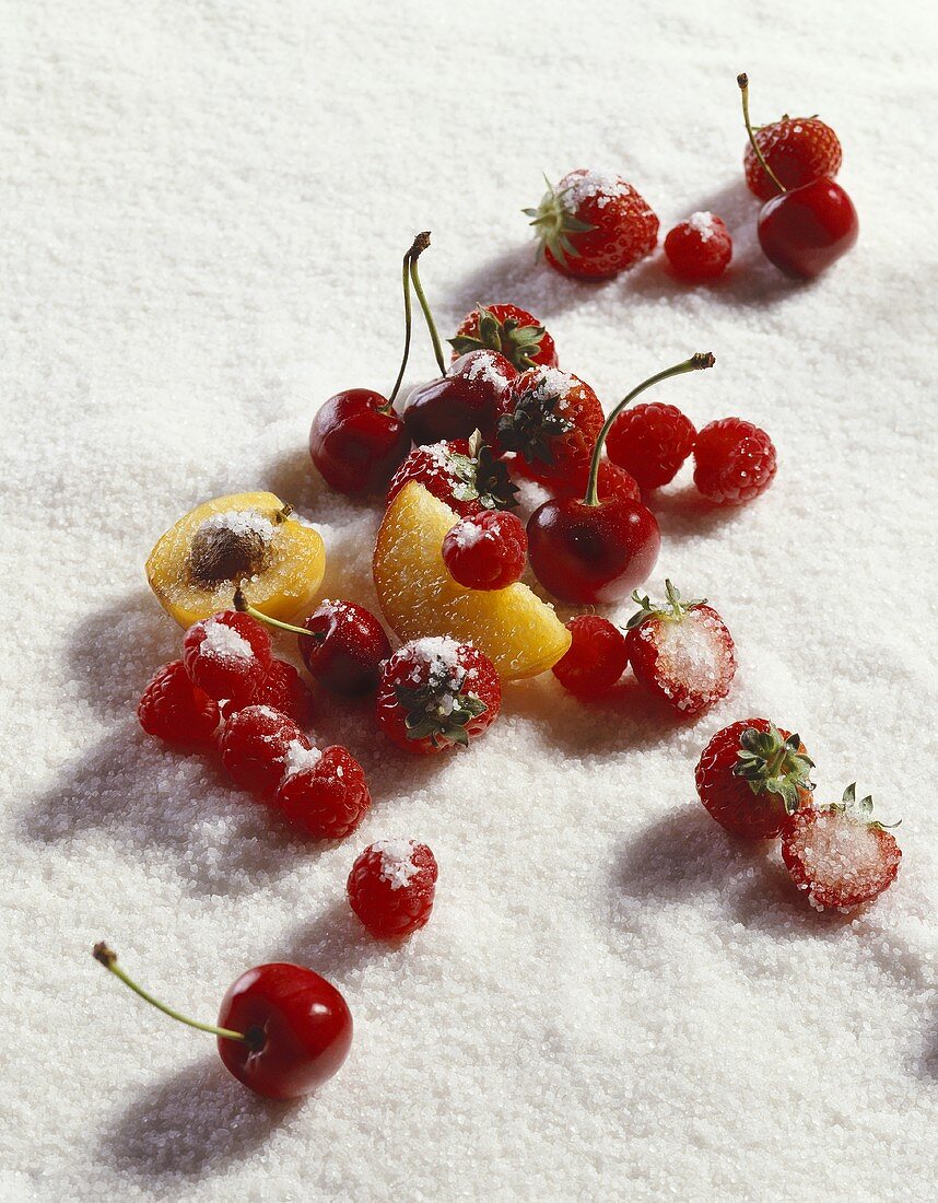 Berries, cherries, pieces of apricot and peach on sugar