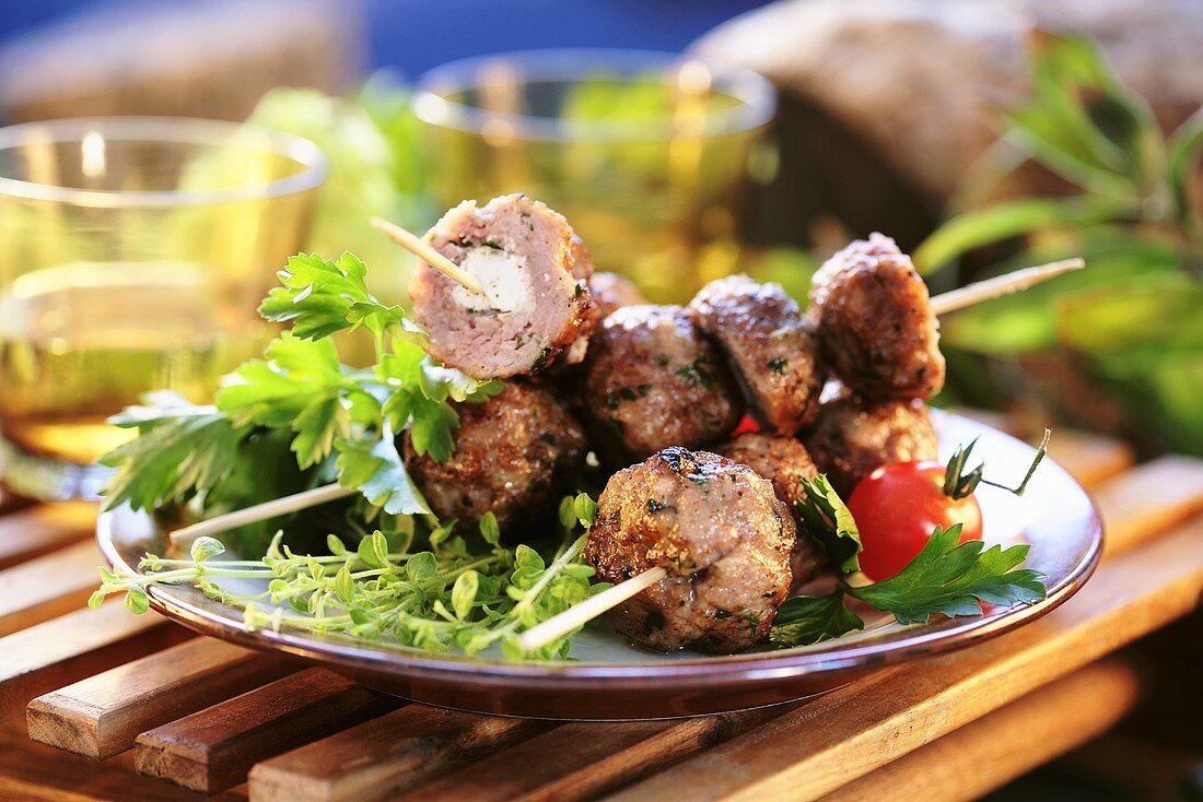 Meatballs stuffed with feta cheese, grilled on skewers
