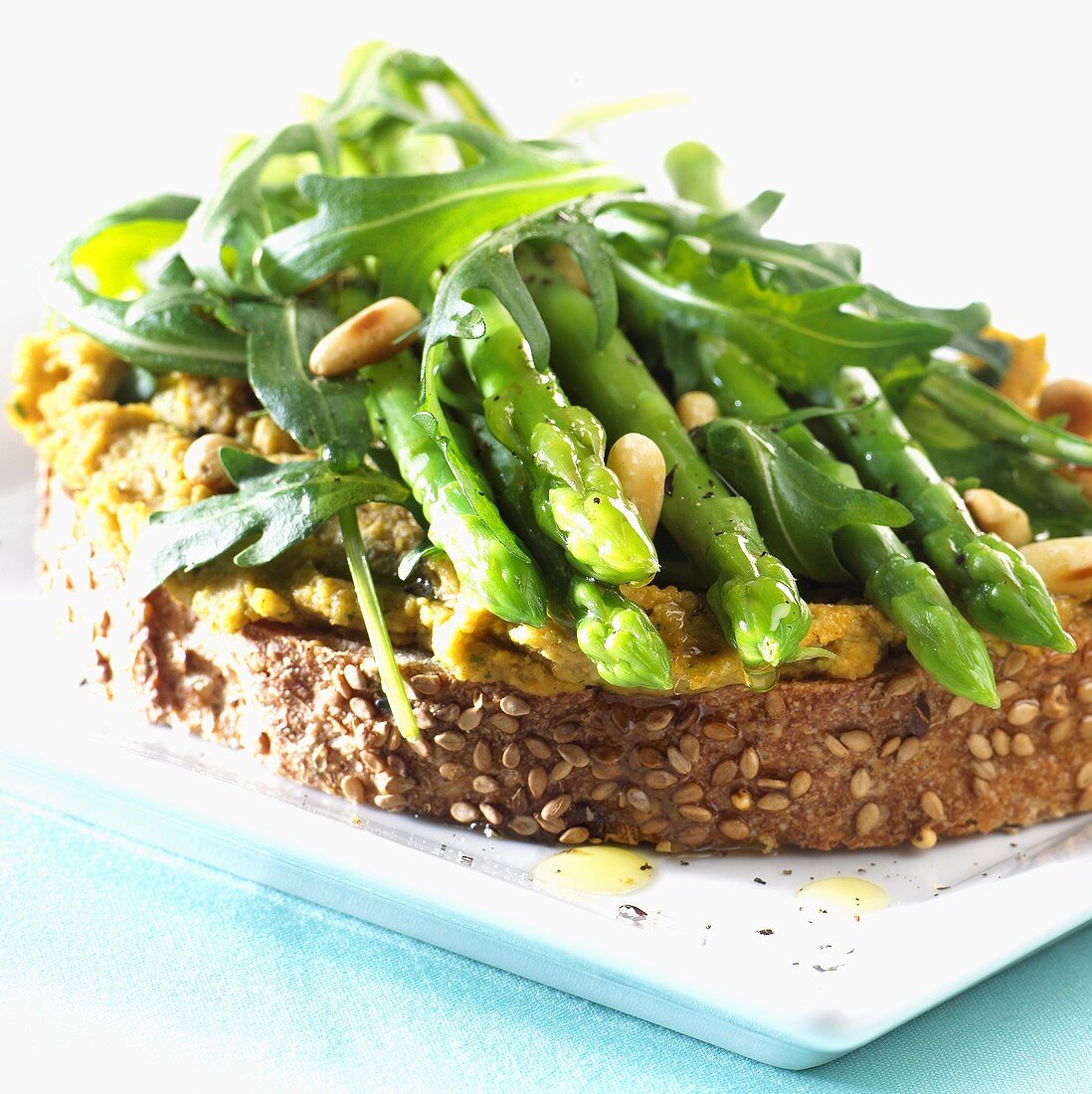 Green asparagus, rocket, pine nuts & hummus on sesame bread