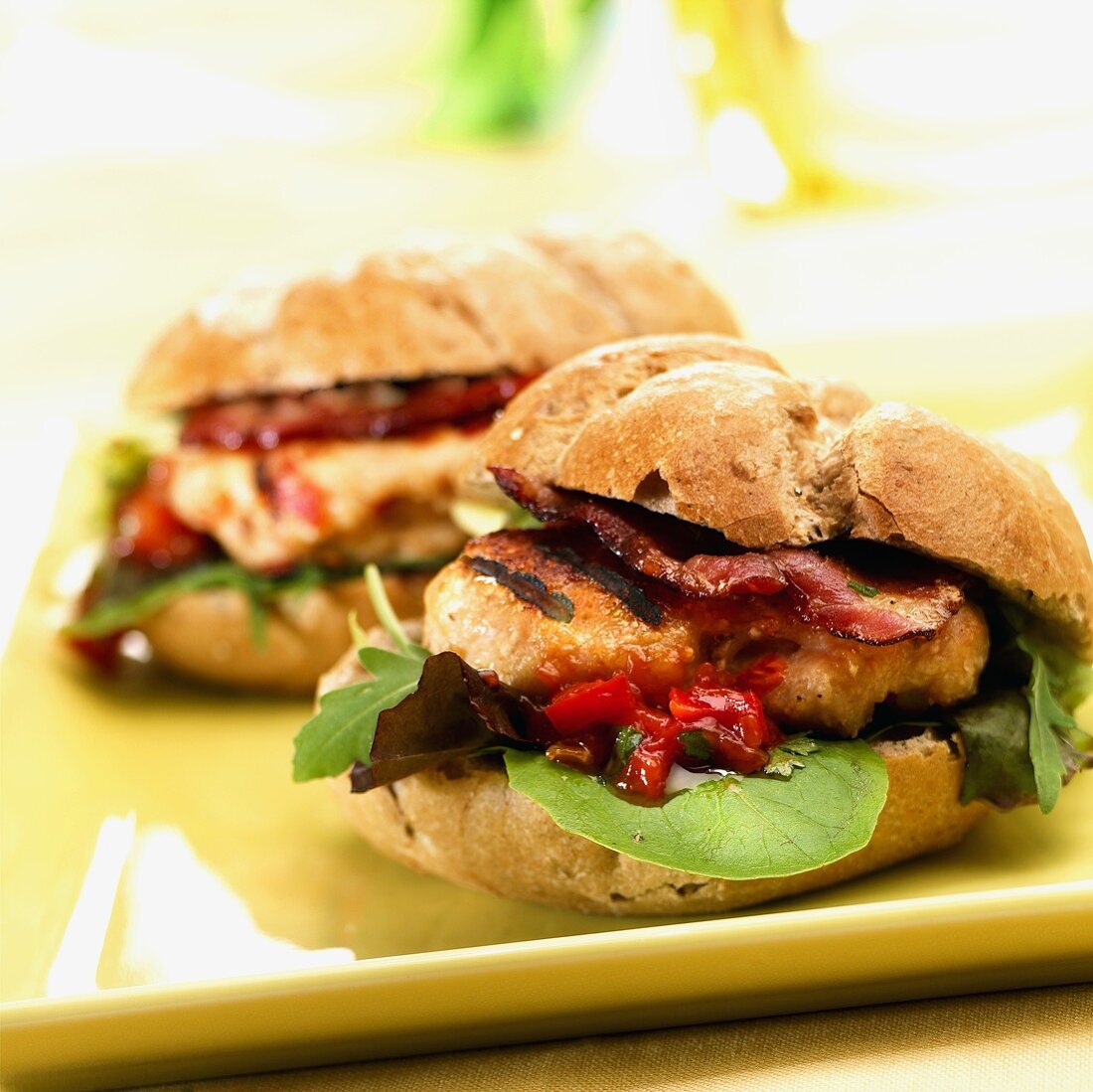 Two chicken burgers with bacon and barbecue sauce