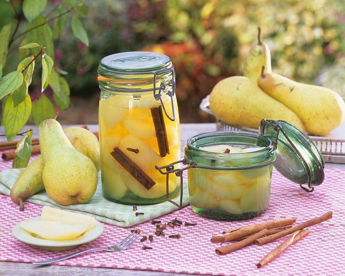 Bottled pears in preserving jars, fresh pears, spices