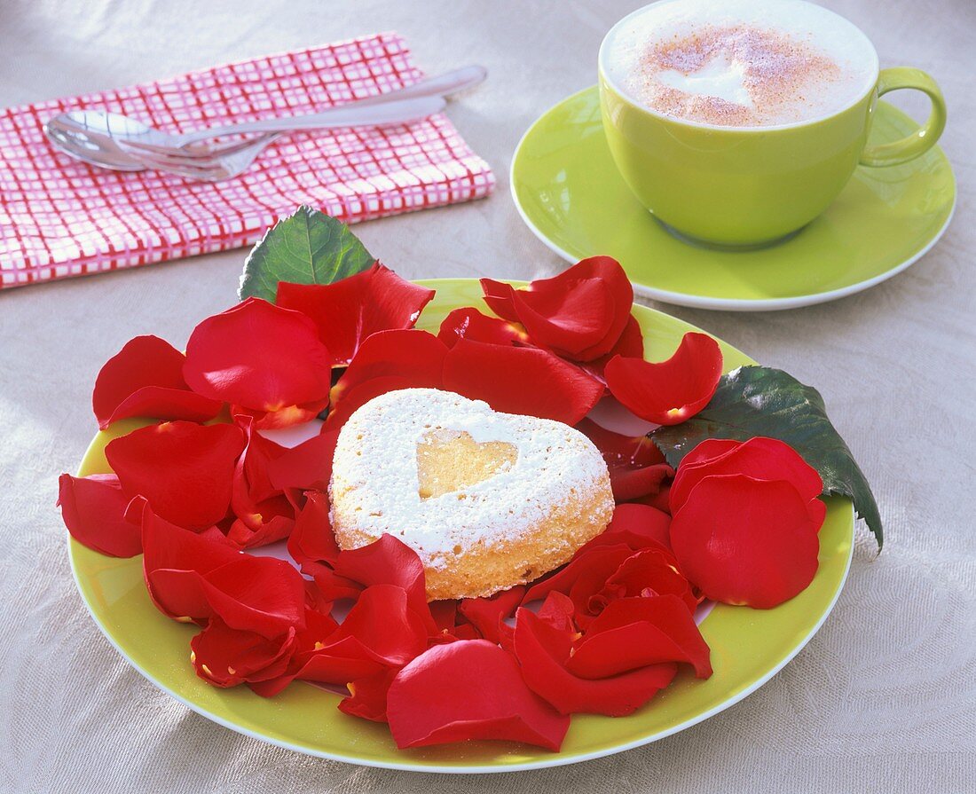 Small heart-shaped cake on rose petals