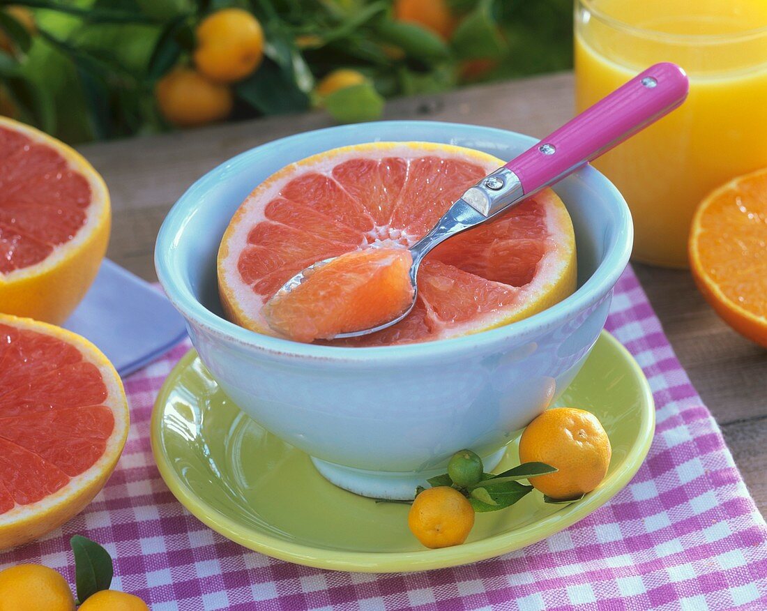 Half a grapefruit in a bowl and orange juice