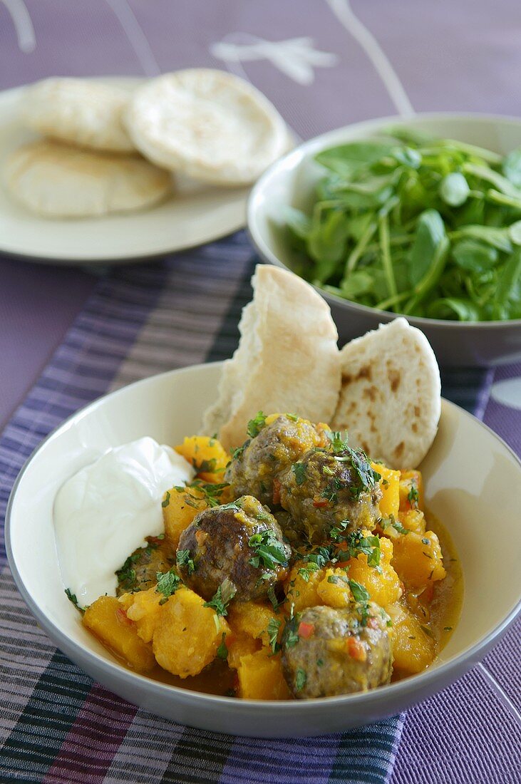 Braised butternut squash with meatballs and pita bread