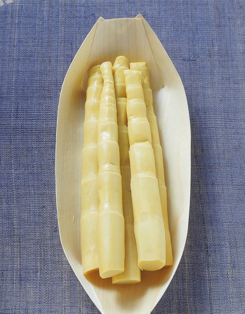 Five bamboo shoots in a light wooden dish