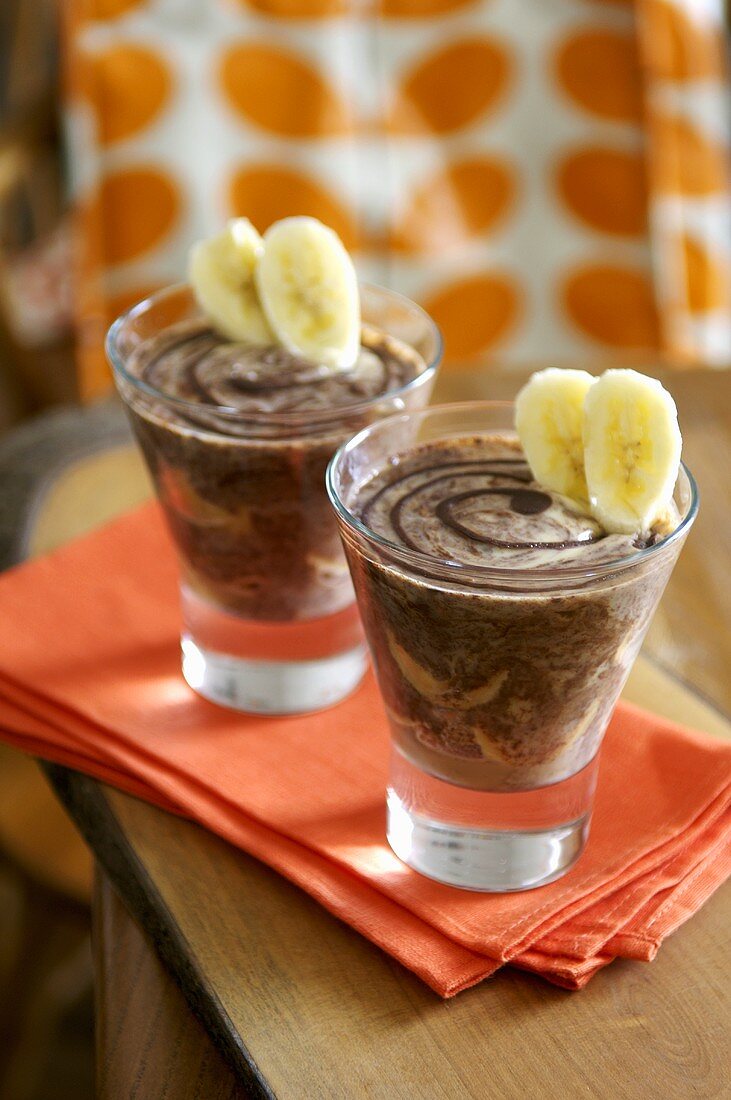 Chocolate custard with banana in two schnapps glasses